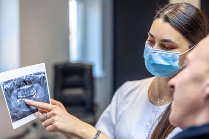 Female dentist examining a patient’s dental X-ray