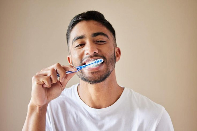 a man is brushing his teeth after smoking