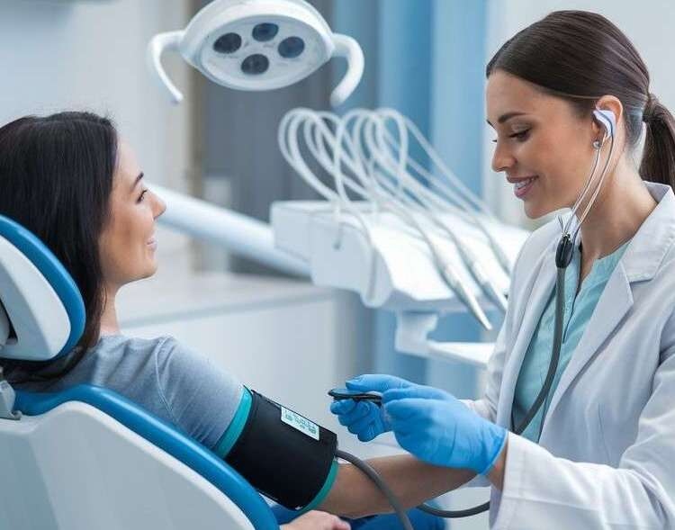 Female dentist measuring a patient’s blood pressure at the clinic
