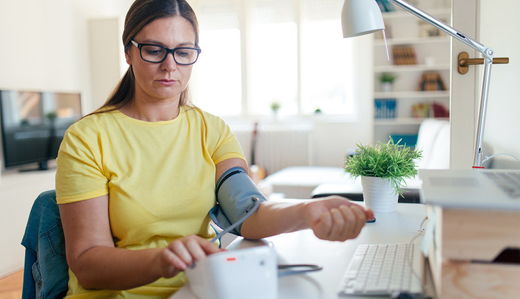woman checking blood pressure at home