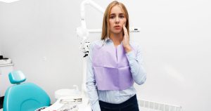 Anxious patient after dental cleaning concerned about tooth chip or damage in dental clinic