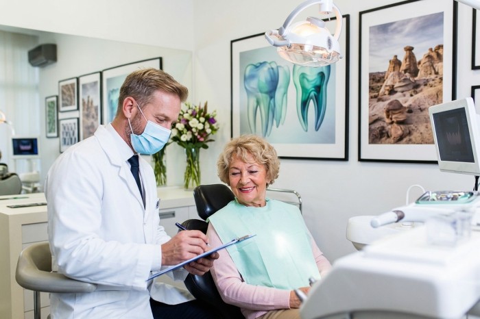 A male dentist consulting with a patient to determine the right treatment for brown stains on teeth